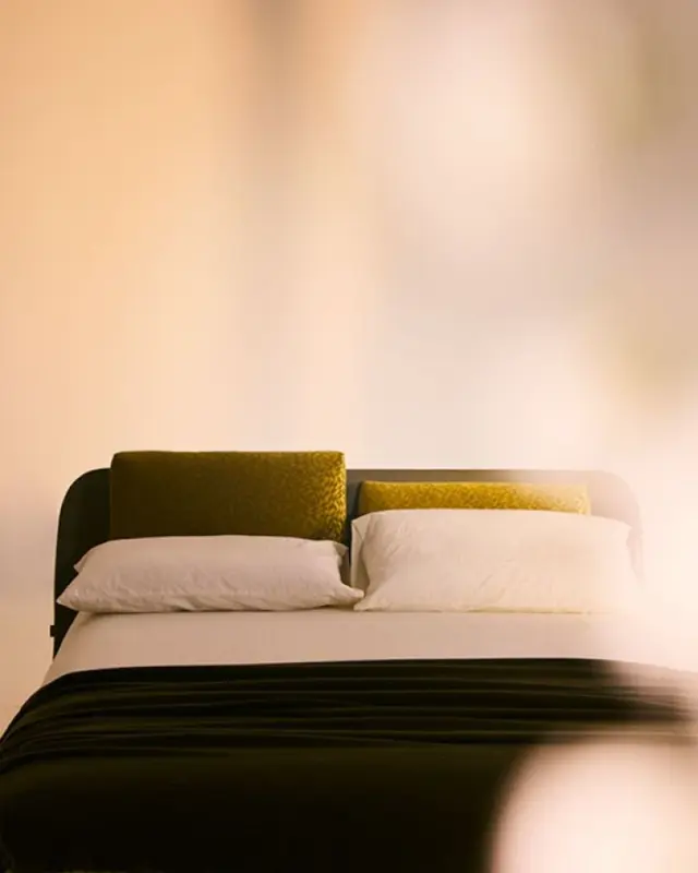 Cama Tata de Bolzan con estructura en madera maciza revestida en piel y cabecero con cojines ajustables.