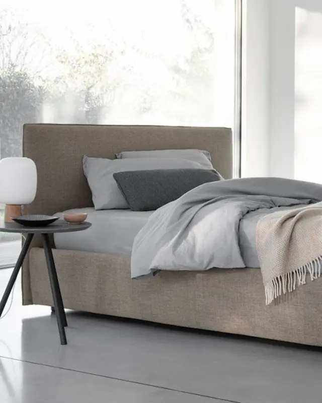 Cama Gaya de Bolzan tapizada en tejido suave con diseño atemporal y cabecero personalizable para todo tipo de dormitorios.