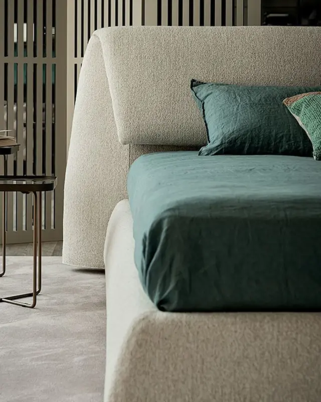 Cama Simon de Cattelan Italia con estructura baja y cabecero acolchado curvo en ambiente de dormitorio moderno.