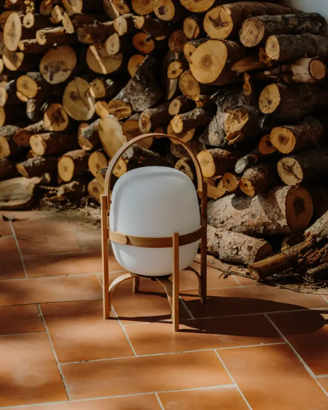 Lámpara portátil Cestita Batería de Santa & Cole con estructura de madera y globo difusor.